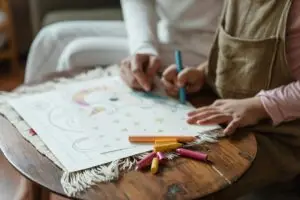 A cozy moment of bonding between a mother and child while coloring indoors.